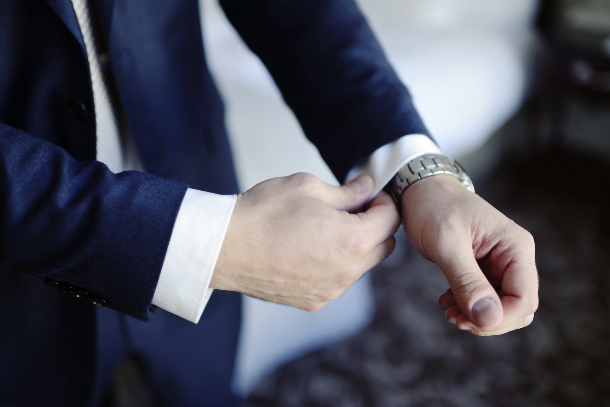 Groom is wearing a suit indoors